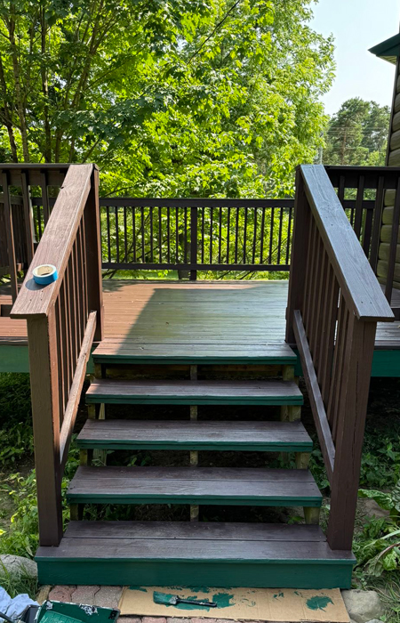 Deck steps leading to a clean wooden deck surrounded by greenery, illustrating the benefits of pressure washing for home maintenance and safety.